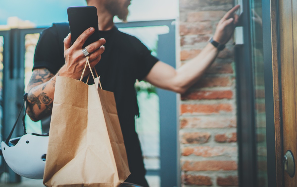 man delivering groceries using mobile app 254761012
